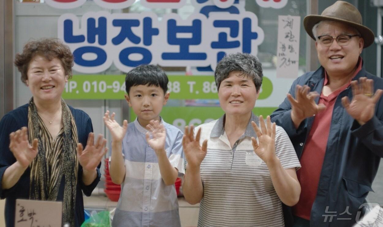 본문 이미지 - '초등래퍼' 차노을 군이 전통시장 상인들과 기념 촬영을 하고 있다.(중소벤처기업부 제공) ⓒ News1