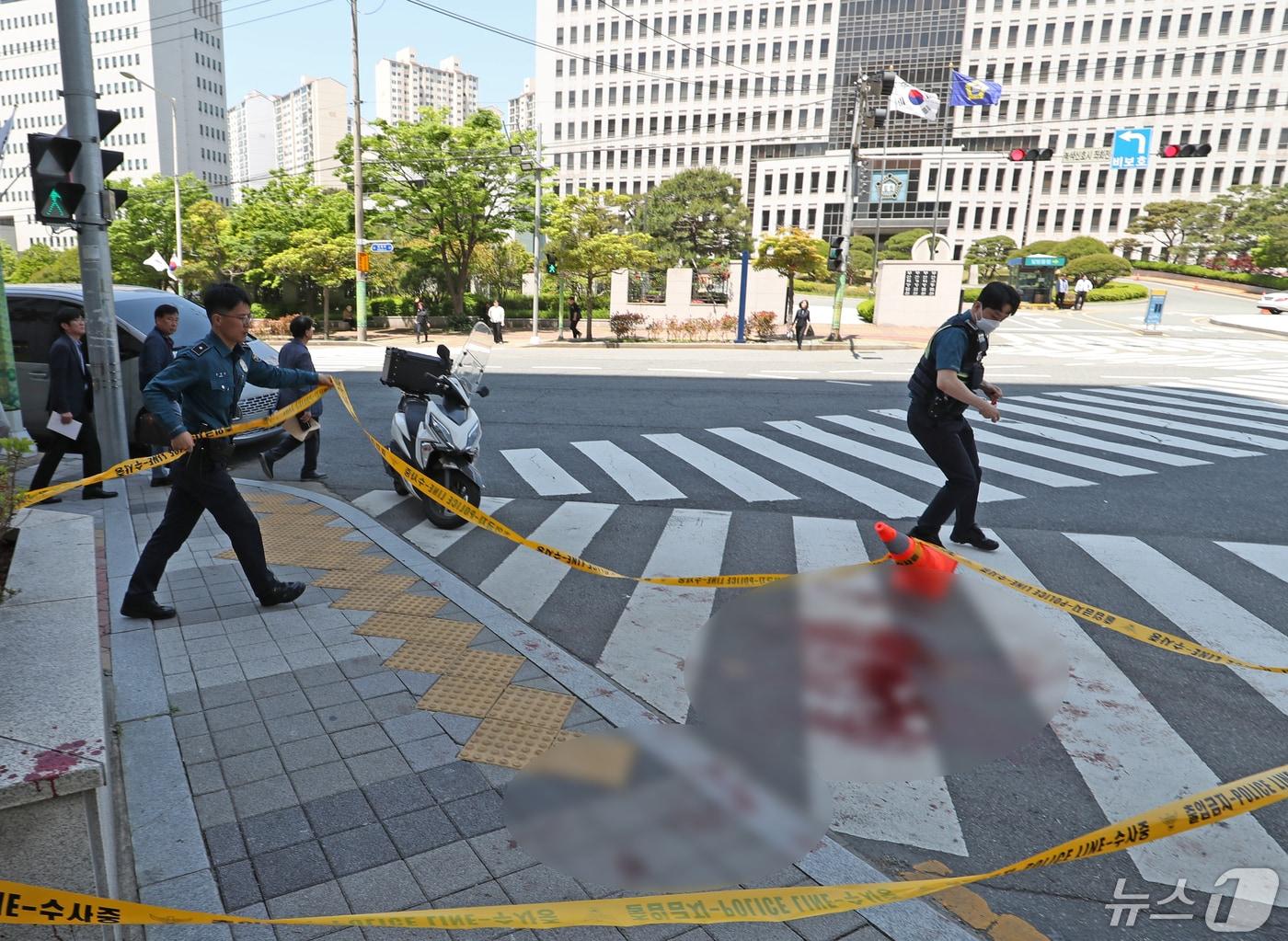 본문 이미지 - 9일 오전 부산 연제구 부산지방법원 앞에서 유튜브 채널을 운영하는 50대 남성이 또 다른 유튜버인 50대 남성에게 흉기로 찌른 사건이 발생한 가운데 경찰관들이 사건 현장을 정리하고 있다. 피해자는 심정지 상태에서 병원으로 이송됐으나 사망했다. 경찰은 도주한 용의자를 경북 경주에서 검거했다. 2024.5.9/뉴스1 ⓒ News1 윤일지 기자