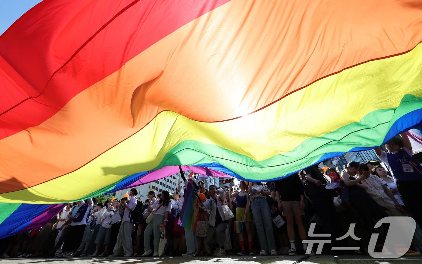 본문 이미지 - 1일 오후 서울 종각역 일대에서 열린 '2024 서울퀴어문화축제'를 찾은 시민들이 무지개 깃발이 펼쳐지자 환호하고 있다. 2024.6.1/뉴스1 ⓒ News1 이동해 기자