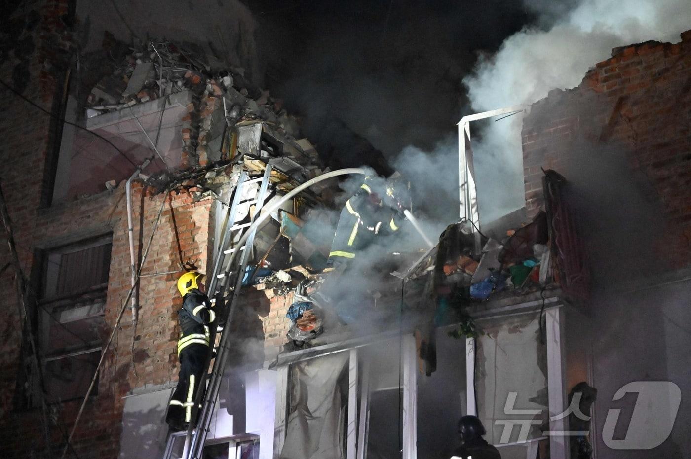 본문 이미지 - 우크라이나 하르키우에서 소방대원들이 러시아의 미사일 공격으로 파괴된 아파트의 화재를 진압하고 있다. 공격은 미국이 우크라이나에 러시아 본토 타격을 위해 미국 무기 사용을 승인한 후 이뤄졌으며, 이날 이 마을에서는 총 3명이 숨졌다. 2024.05.31/ ⓒ AFP=뉴스1 ⓒ News1 권진영 기자