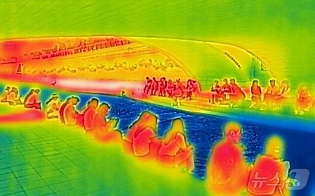 본문 이미지 - 전국 대부분 지역의 낮 최고 기온이 30도에 이르며 더위가 이어진 10일 서울 청계천을 찾은 시민들이 그늘 밑에서 휴식을 취하고 있다. 열화상카메라 화상은 온도가 높을수록 붉은색으로 나타나며 상대적으로 온도가 낮은 곳은 푸른색으로 나타난다. (열화상 카메라 촬영) 2024.6.10/뉴스1 ⓒ News1 김도우 기자