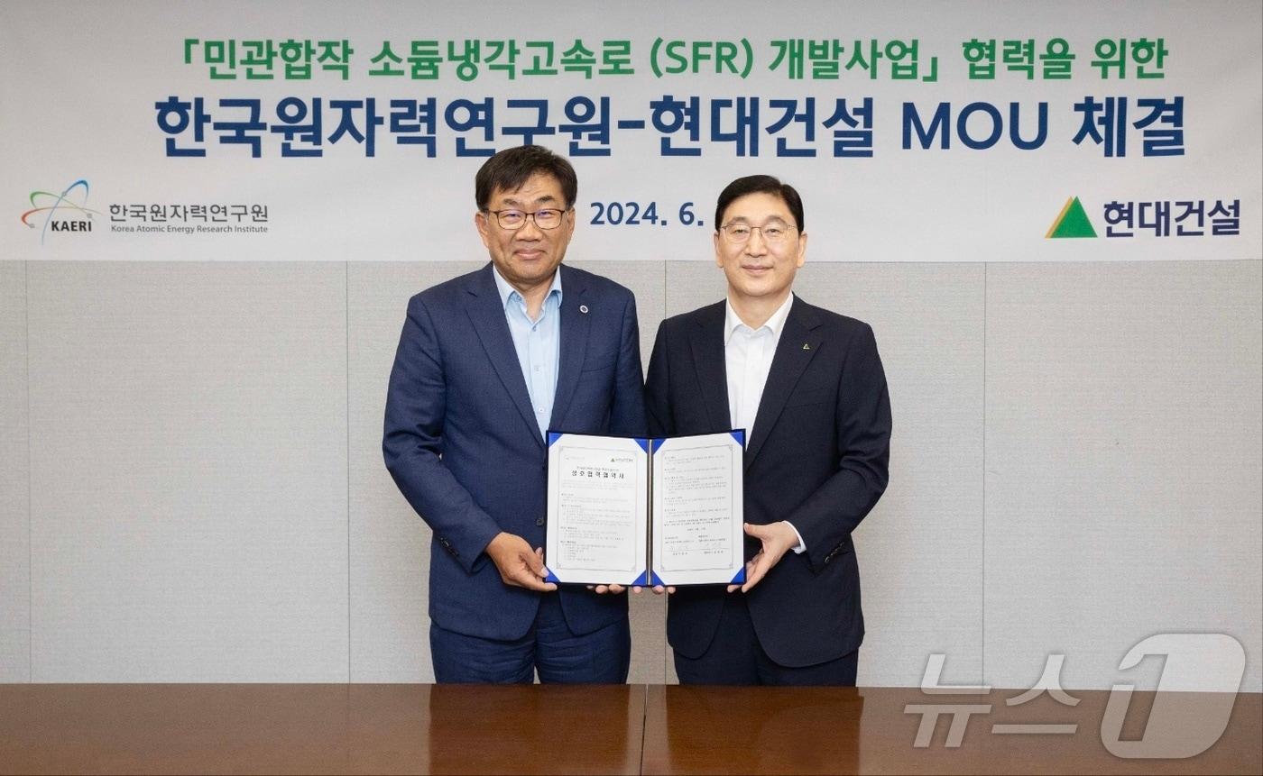 본문 이미지 - 11일 서울 종로구 계동의 현대건설 본사에서 윤영준 현대건설 사장(오른쪽)과 주한규 한국원자력연구원 원장(왼쪽)이 '민관합작 소듐냉각고속로 개발사업에 관한 업무협약'을 체결한 후 기념사진을 촬영하고 있다.(현대건설 제공)