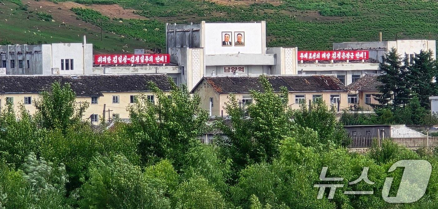 지난 12일 중국과 북한의 국경지역인 중국 지린성 옌볜 조선족자치주 도문시 두만강 강변공원에서 두만강 너머로 김일성·김정일의 대형 초상화가 그려진 북한 함경북도 온성군(남양노동자구) 남양역이 보이고 있다. (공동취재) 2024.6.17/뉴스1 ⓒ News1 이재명 기자