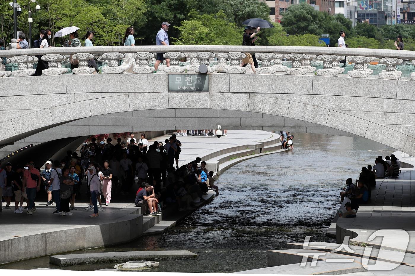 본문 이미지 - 서울의 낮 최고기온이 30도를 기록하는 등 불볕더위가 계속된 17일 오후 서울 중구 청계천 모전교 아래에서 시민들이 더위를 식히고 있다. 기상청은 당분간 맑은 가운데 자외선 지수와 오존 농도가 매우 높게 치솟을 것으로 예상하며 자외선 차단과 한낮 야외활동 자제를 당부했다. 2024.6.17/뉴스1 ⓒ News1 오대일 기자