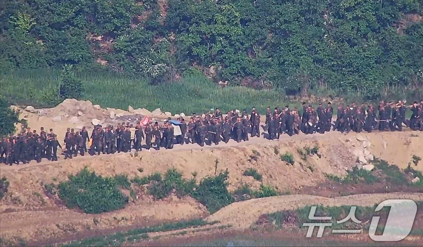 본문 이미지 - 합동참모본부는 북한이 4월경부터 북방한계선 등 전선지역 수 개소에서 다수병력을 투입해 경계력 보강 일환 불모지 조성, 지뢰매설, 전술도로 보강, 대전차 방벽으로 보이는 미상 구조물 설치 등 다양한 형태의 작업을 진행 중이라고 18일 밝혔다. 사진은 대규모 북한군이 전선지역에 투입된 모습 .(합참 제공) 2024.6.18/뉴스1