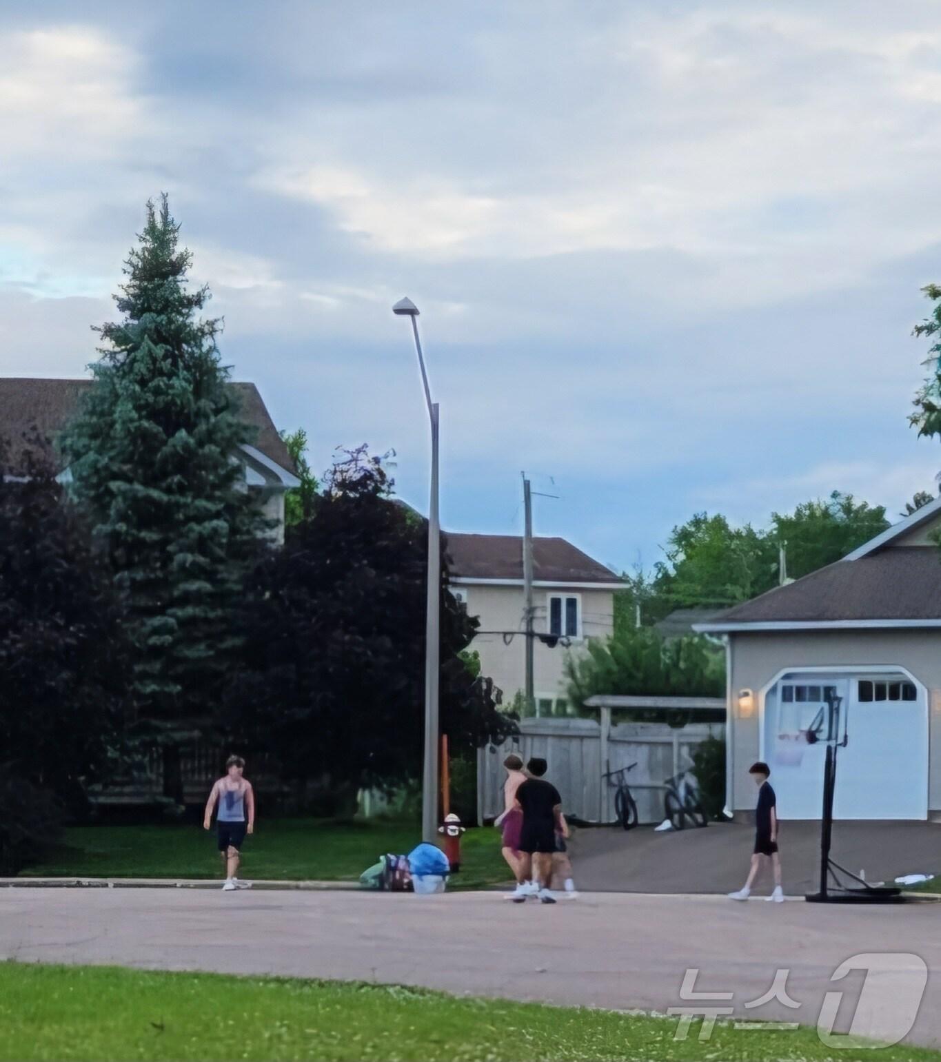 본문 이미지 - 오후가 되면 동네 이곳저곳에서는 집 앞에서 농구를 하는 청소년들의 모습을 많이 볼 수 있고, 인라인을 타는 어린이돌, 바닥에 그림을 그리며 노는 어린이들의 모습을 흔히 볼 수 있다. 동네 길거리가 아이들의 놀이터가 된다. 몽튼 지역 청소년들의 모습. 2024.06. 17 ⓒ 뉴스1 김남희 통신원