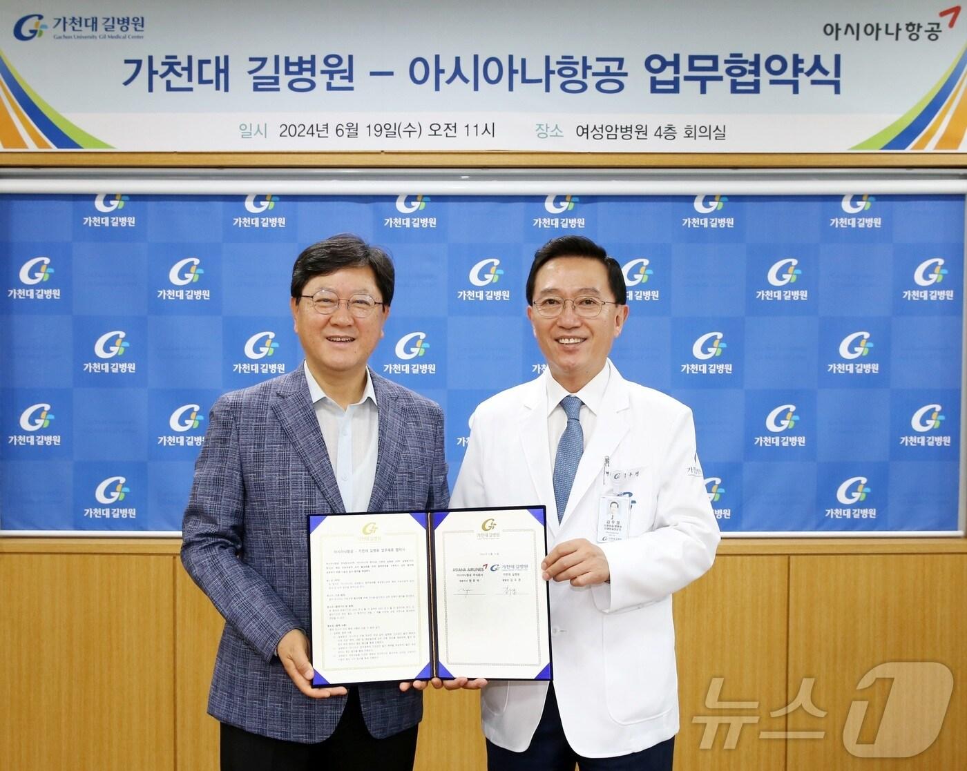본문 이미지 -  아시아나항공이 19일 가천대 길병원과 방한 외국인 의료 관광객 유치를 위한 업무 협약을 체결했다. 아시아나항공 원유석 사장(왼쪽)과 가천대 길병원 김우경 병원장이 기념 촬영을 하고 있다.(아시아나항공 제공)
