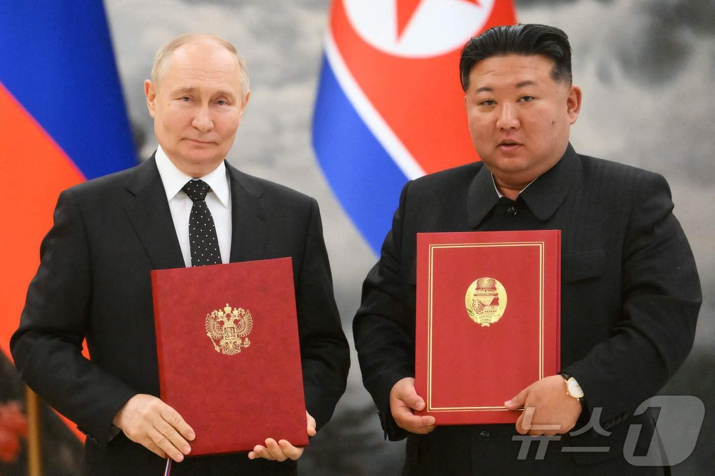 김정은 북한 국무위원장과 블라디미르 푸틴 러시아 대통령이 19일(현지시간) 평양의 금수산 영빈관에서 회담을 마친 뒤 '포괄적 전략 동반자 협정서'를 들고 포즈를 취하고 있다. 2024.06.20 ⓒ AFP=뉴스1 ⓒ News1 우동명 기자