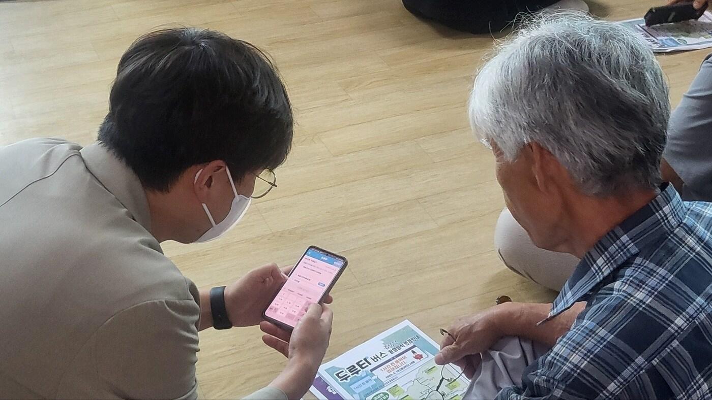 세종도시교통공사  직원(왼쪽)이 20일 금남면 원봉2리 마을회관에서 두루타 앱 설치 방법을 설명하고 있다. (세종도시교통공사 제공) / 뉴스1