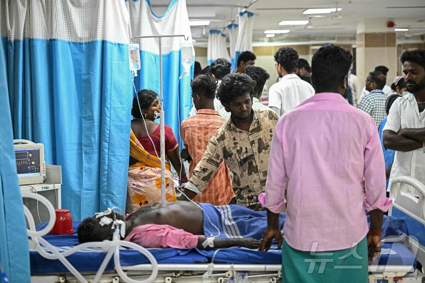 인도 타밀나두주 칼라쿠리치에서 메탄올을 섞은 밀주를 마시고 입원한 환자를 20일(현지시간) 가족들이 병문안하고 있다. 보건당국은 메탄올이 섞인 술을 마시고 최소 34명이 숨졌으며 100명 이상이 병원으로 이송됐다고 밝혔다. 2024.06.20. ⓒ AFP=뉴스1 ⓒ News1 김민재 기자