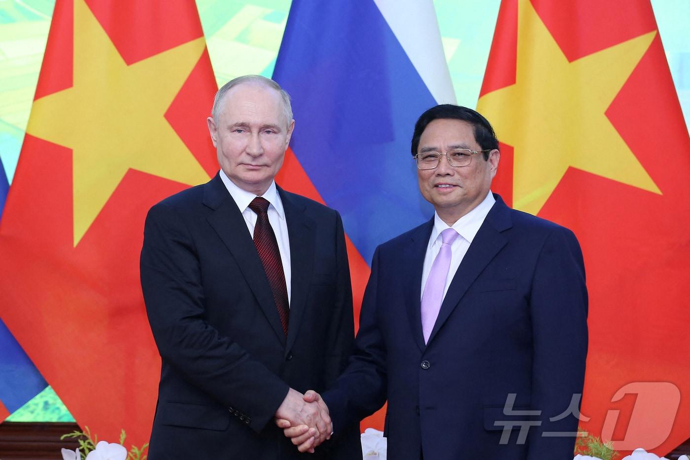 블라디미르 푸틴 러시아 대통령이 20일 (현지시간) 하노이 정부 청사에서 팜민찐 베트남 총리와 만나 악수를 하고 있다. 2024.06.21 ⓒ 로이터=뉴스1 ⓒ News1 우동명 기자