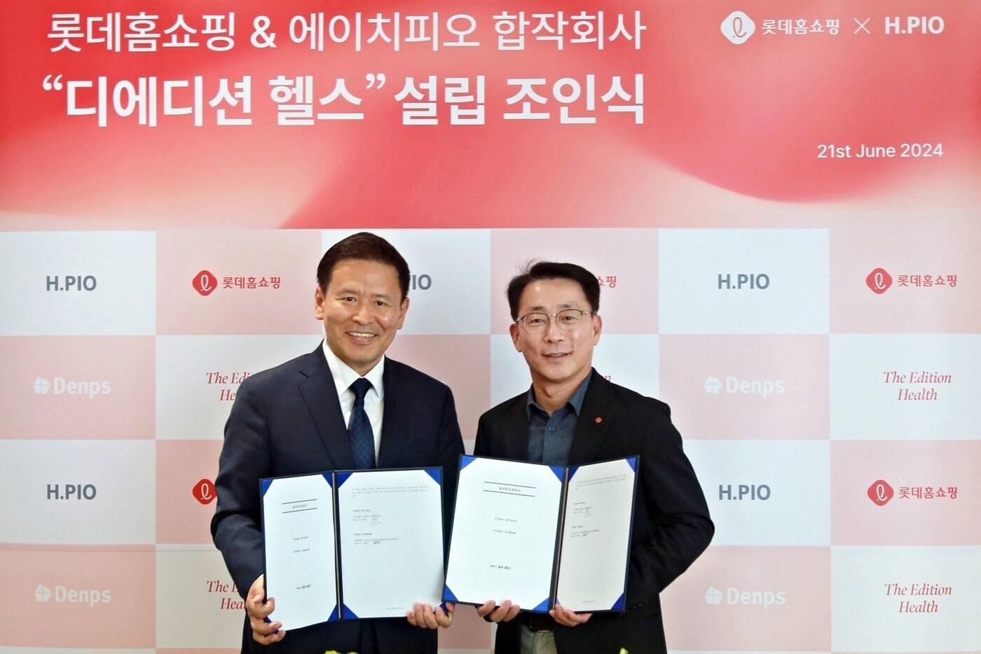 김재겸 롯데홈쇼핑 대표(오른쪽)와 민택근 에이치피오 대표가 21일 서울 용산구 에이치피오 사무실에서 합작회사 '디에디션 헬스' 설립 조인식을 열고 기념촬영을 하고 있다(롯데홈쇼핑 제공).