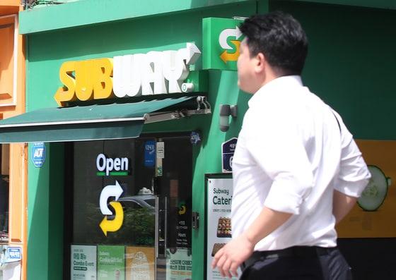 본문 이미지 - 서울 시내에 위치한 써브웨이 매장 앞을 한 시민이 지나고 있다. 2024.6.24 ⓒ 뉴스1 임세영 기자