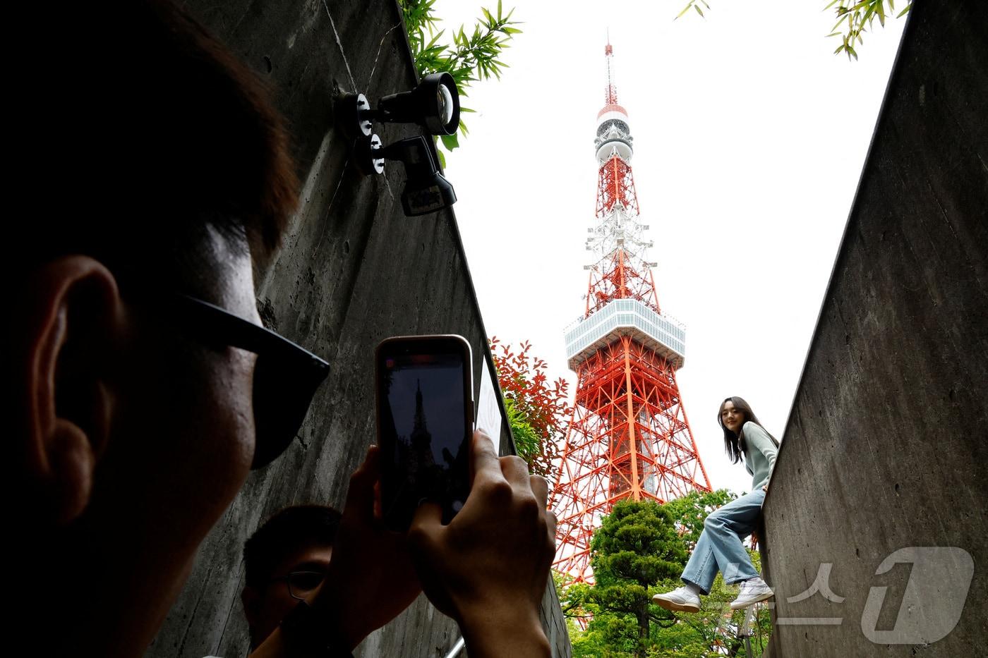 도쿄 온 관광객이 도쿄타워를 찍고 있다. 2024.04.26 ⓒ 로이터=뉴스1 ⓒ News1 임여익 기자