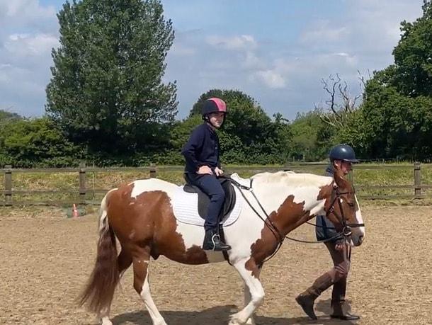 본문 이미지 - 뇌전증을 앓던 오란 놀슨&#40;13&#41;이 뇌심부자극술&#40;DBS&#41; 이후 발작 증세가 호전돼 승마를 배우는 모습.&#40;영국 NHS 트러스트 재단 홈페이지 갈무리&#41; 2024.06.24/