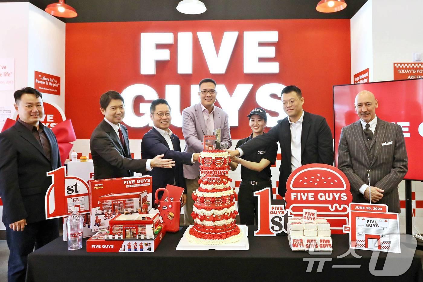 김동선 한화갤러리아 부사장(왼쪽 네 번째)이 지난해 6월26일 서울 서초구 파이브가이즈 강남에서 열린 파이브가이즈 국내 오픈 1주년 기념 행사에서 기념 케이크를 자르고 있다. (파이브가이즈 제공) 2024.6.26/뉴스1