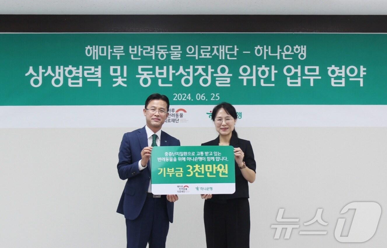 본문 이미지 - 서유석 하나은행 본부장(왼쪽)이 25일 성남 분당구 하나은행 남부영업본부에서 김소현 해마루반려동물의료재단 이사장에게 기부금을 전달하고 있다(해마루 제공). ⓒ 뉴스1