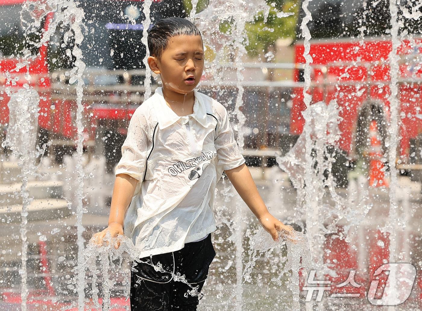 본문 이미지 - 서울 지역 낮 최고기온이 30도를 웃돌며 찜통더위를 보인 28일 서울 종로구 광화문광장 분수대를 찾은 어린이가 물놀이를 즐기며 더위를 식히고 있다. 2024.6.28/뉴스1 ⓒ News1 김진환 기자