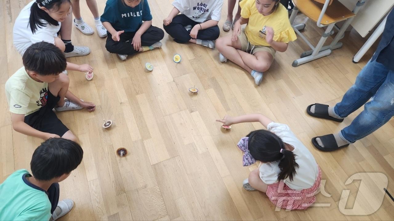 본문 이미지 - 충북도교육청 교육도서관 다문화 통합 독서 프로그램에서 전통 팽이놀이를 하는 학생들.(충북교육청 제공)/뉴스1