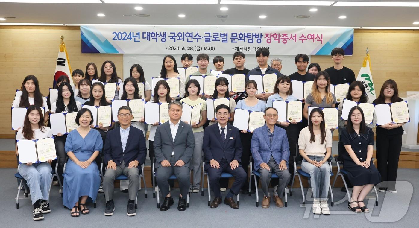 본문 이미지 - 2024년 대학생 국외연수·글로벌 문화탐방 장학증서 수여식에서 참석자들이 단체사진을 찍고 있다. 앞줄 오른쪽 네번째가 이응우 시장 /뉴스1