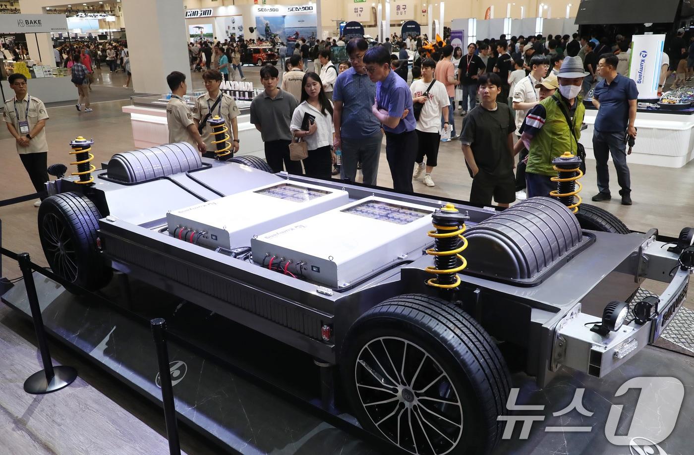 28일 부산 해운대구 벡스코 제1전시장에서 열린 &#39;2024 부산모빌리티쇼&#39;에서 관람객들이 4695 원통형 배터리를 장착한 4륜구동 완성차 모형을 둘러보고 있다. 2024.6.28/뉴스1 ⓒ News1 윤일지 기자