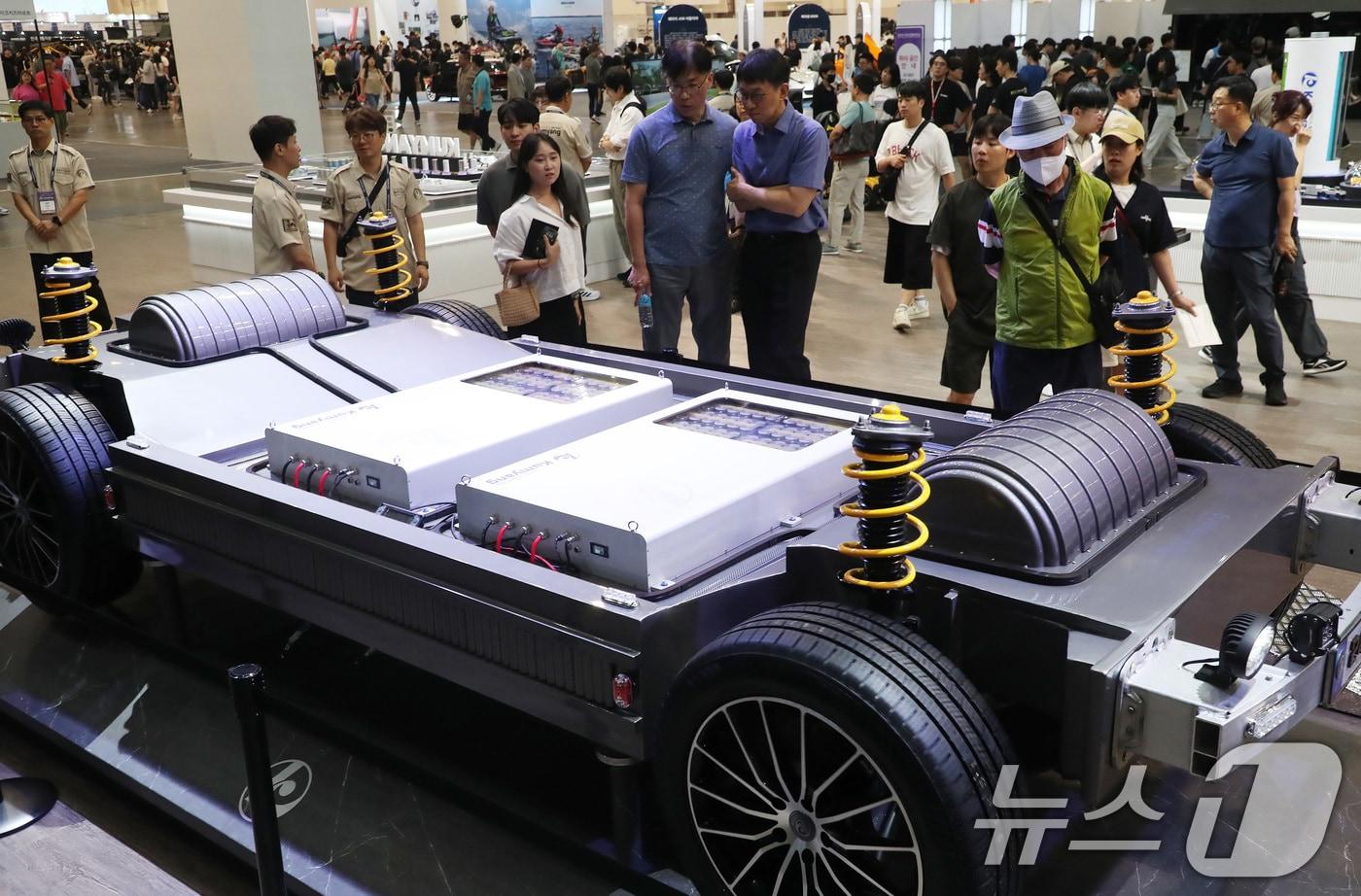 28일 부산 해운대구 벡스코 제1전시장에서 열린 '2024 부산모빌리티쇼'에서 관람객들이 4695 원통형 배터리를 장착한 4륜구동 완성차 모형을 둘러보고 있다. 2024.6.28/뉴스1 ⓒ News1 윤일지 기자