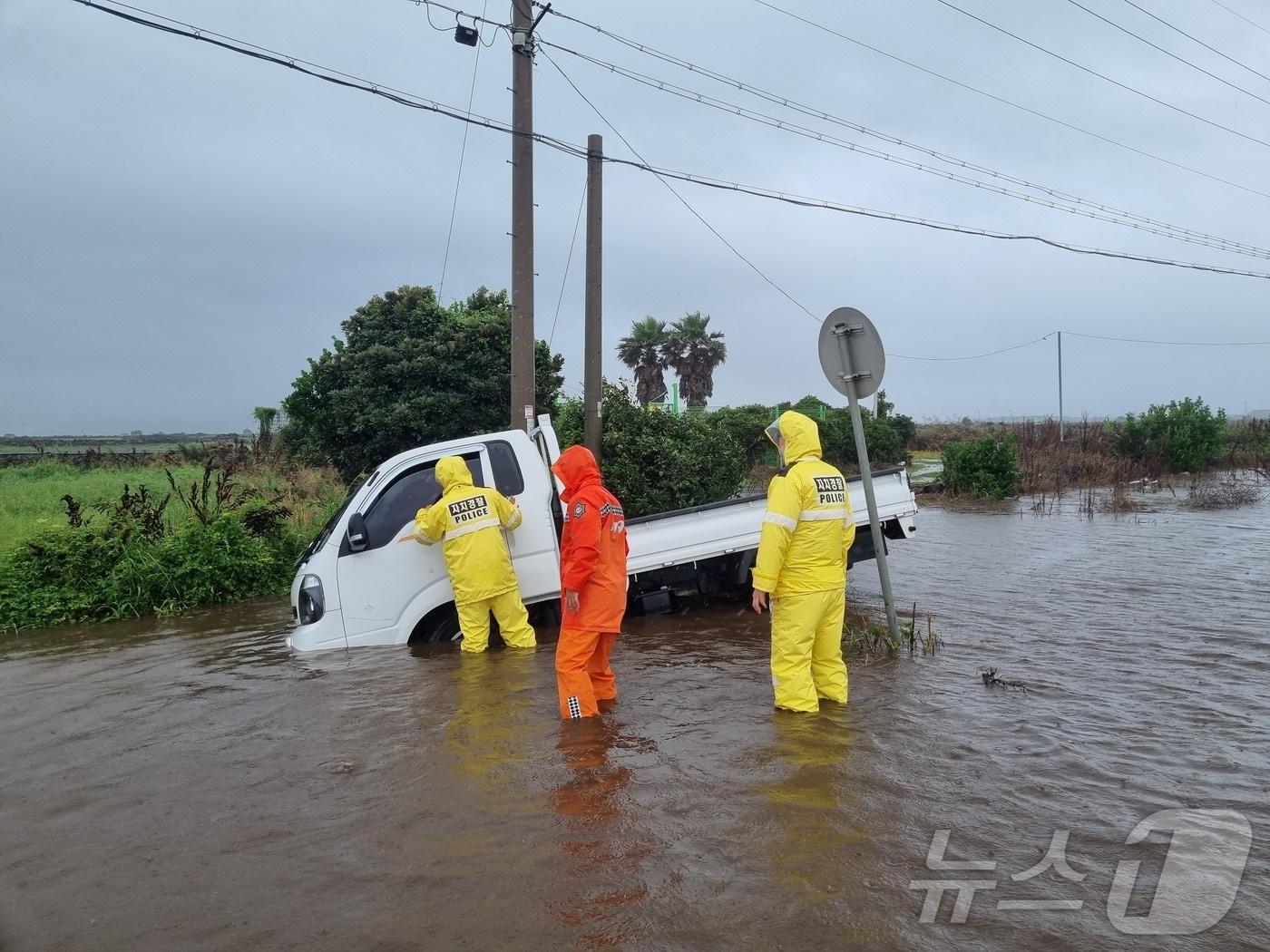 본문 이미지 - 29일 오후 서귀포시 대정읍에서 1톤 트럭이 물이 가득 찬 도로에 빠져 소방이 안전조치 하고 있다.(제주소방안전본부 제공)