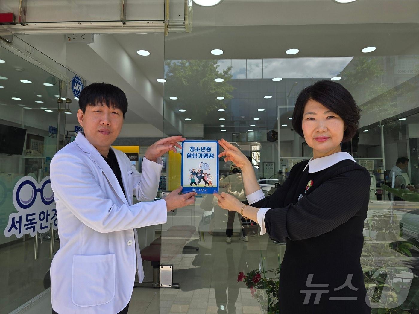 본문 이미지 - 고창군이 청소년증 할인가맹점과 협약을 맺고 협약업체에 가맹점 표지판을 부착했다. 최선임(오른쪽) 인재양성과장이 배준일 서독안경점 대표에게 가맹점 표지판을 전하고 있다.(고창군 제공)2024.6.3/뉴스1 