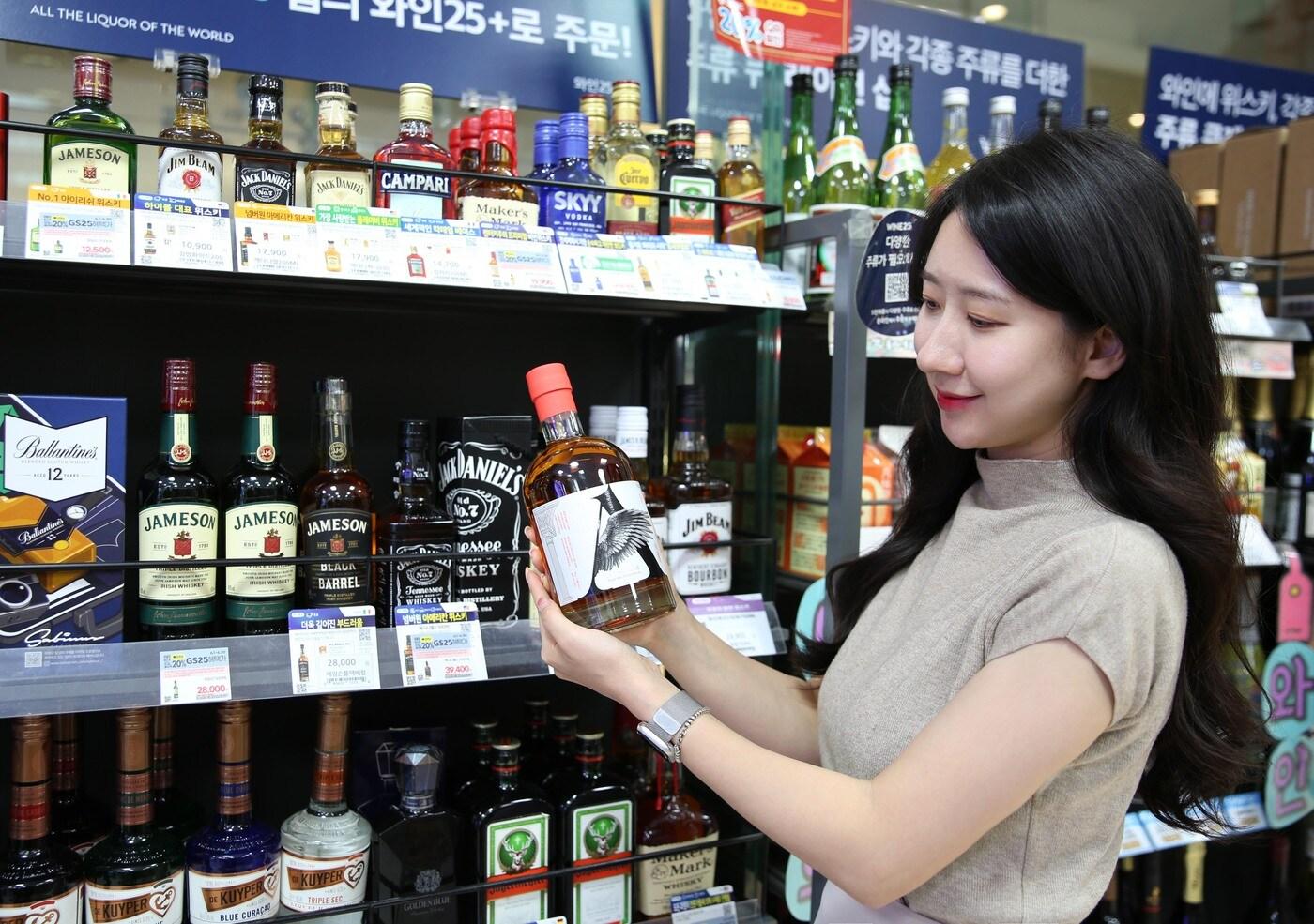 GS25에서 모델이 엔젤캐스크 싱글 몰트 스카치 위스키를 보고 있다(GS리테일 제공).