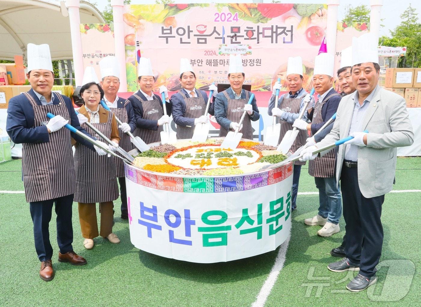 본문 이미지 -  부안군은 5일 부안 해뜰마루해뜰마루 지방정원 일원에서 '2024년 부안음식문화대전'을 개최했다. 권익현 군수를 비롯해 참석자들이 부안비빔밥 비빔행사를 하고 있다.(부안군 제공)2024.6.5/뉴스1