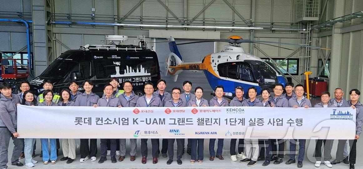 본문 이미지 -  롯데UAM컨소시엄인 롯데렌탈, 롯데건설, 롯데이노베이트 임직원이 K-UAM GC1단계 실증 사업을 성공적으로 수행하고 기념촬영을 하고 있다. (롯데렌탈 제공)