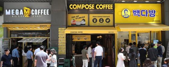 본문 이미지 - 서울 시내에 위치한 저가 브랜드 커피 매장 앞에서 시민들이 줄지어 커피를 구매하고 있다. 2024.7.1 ⓒ 뉴스1 임세영 기자