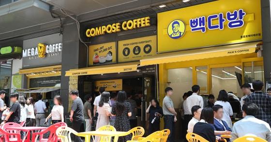 본문 이미지 - 서울 시내에 위치한 저가 브랜드 커피 매장 앞에서 시민들이 줄지어 커피를 구매하고 있다.  2024.7.1 ⓒ 뉴스1 임세영 기자