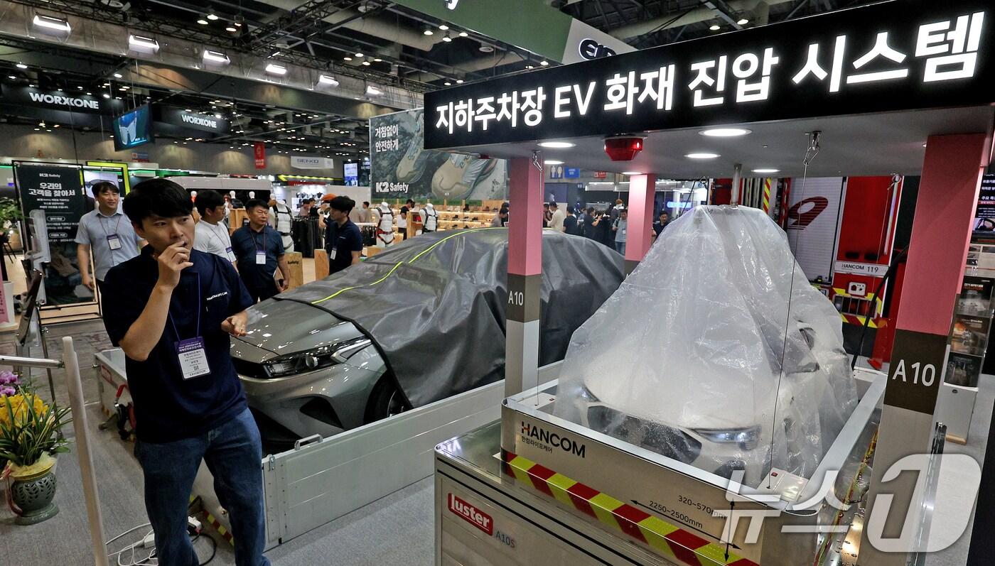 본문 이미지 - 1일 오후 경기 고양시 킨텍스에서 열린 2024 국제안전보건전시회에 참여한 기업 관계자가 지하주차장 전기차 화재 진압 시스템을 설명하고 있다. 2024.7.1/뉴스1 ⓒ News1 장수영 기자