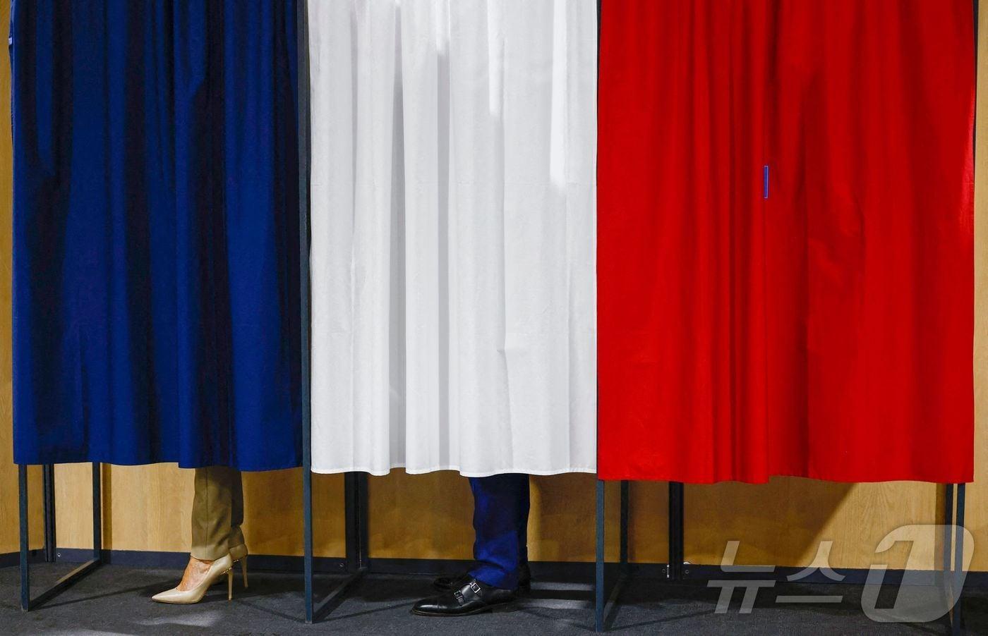 지난달 30일(현지시간) 프랑스 북부의 한 투표소에서 에마뉘엘 마크롱 프랑스 대통령과 부인 브리지트 마크롱이 투표를 하는 모습. 마크롱 대통령이 이끄는 중도 연합은 총선 1차 투표에서 20%의 득표율로 3위에 그쳤다. 2024.06.30/ ⓒ AFP=뉴스1 ⓒ News1 권진영 기자