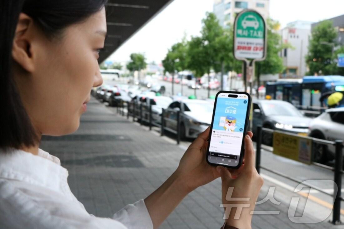 본문 이미지 - 대구신세계백화점 직원이 휴대전화 애플리케이션을 이용해 대구로 택시를 호출하고 있다.(대구신세계 제공)