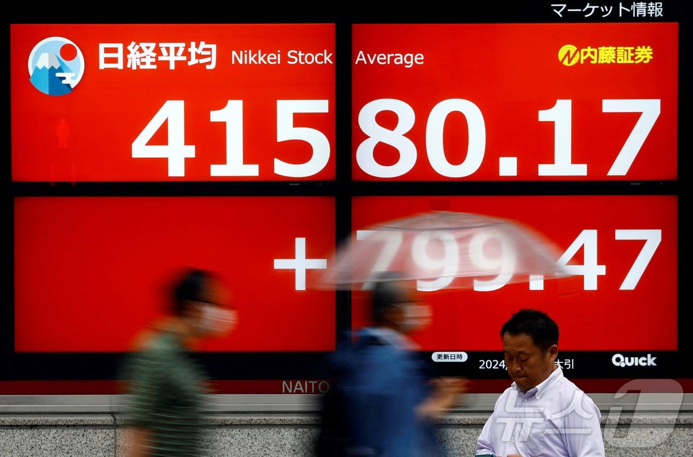 본문 이미지 - 일본 도쿄의 한 증권사 밖, 일본 닛케이 주가 평균을 보여주는 전광판 앞을 지나가는 행인들의 모습이다.2024.07.09/ ⓒ 로이터=뉴스1 ⓒ News1 이강 기자