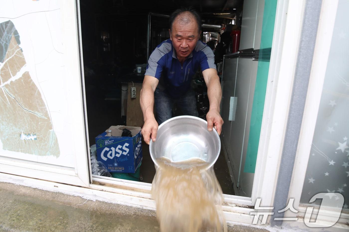 본문 이미지 - 집중호우가 쏟아진 10일 대구 동구 금호강 일부 구간이 범람해 인접한 금강동 주택이 침수되자 주민이 빗물을 퍼내고 있다. 2024.7.10/뉴스1 ⓒ News1 공정식 기자