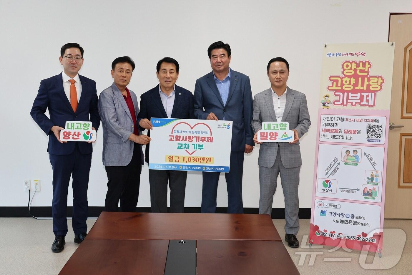 본문 이미지 - 이상훈 농협 밀양시지부장 등 밀양 관내 농축협 임원들이 11일 나동연 양산시장에게 고향사랑기부금을 기탁하고 있다.(양산시 제공)