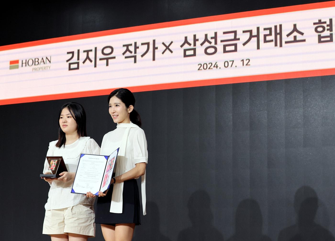 본문 이미지 - 김지우 작가(왼쪽)와 김윤혜 호반프라퍼티 김윤혜 총괄사장이 기념사진츨 촬영하고 있다.(호반그룹 제공)