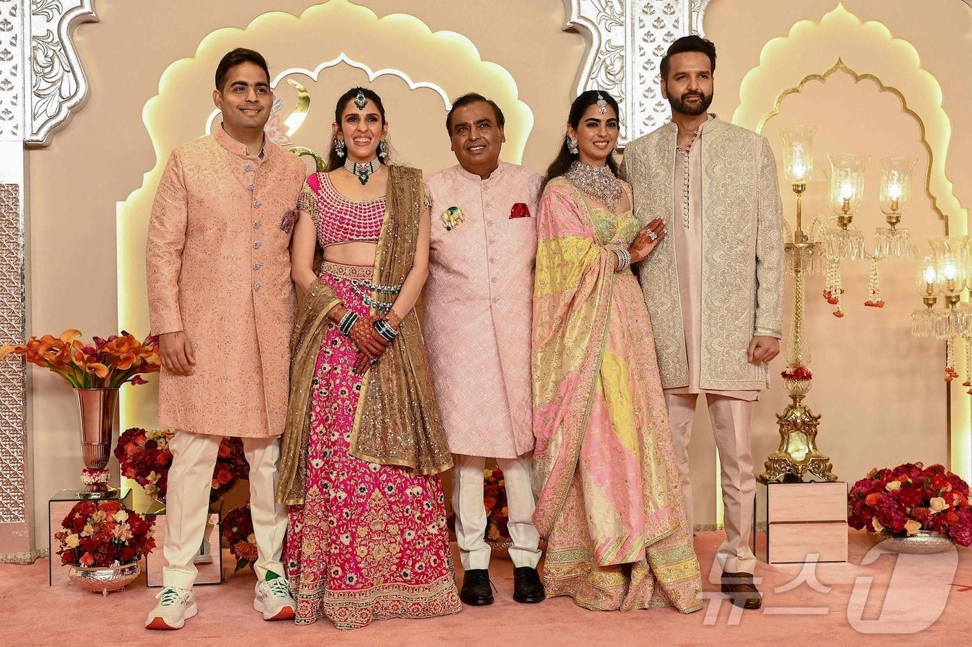 아시아 최고갑부 무케시 암바니 인도 릴라이언스 인더스트리 회장이 12일 뭄바이에서 시작된 막내아들 아난트 암바니의 결혼식에서 장남 아카시 부부(왼쪽), 장녀 이샤 부부(오른쪽)와 가족 사진을 찍고 있다. 3일간 이어지는 초호화판 암바니가(家) '세기의 결혼식'은 장 녀, 장남에 이어 이번이 3번째이다. 2024.07.12 ⓒ AFP=뉴스1 ⓒ News1 이강기자