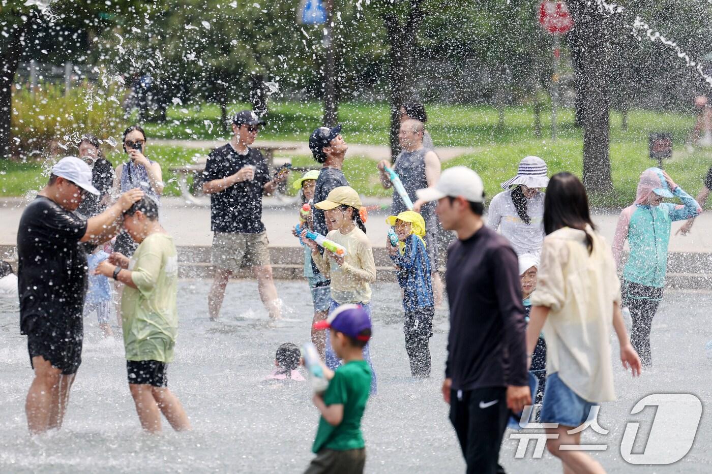 낮 최고기온이 33도까지 올라 무더운 날씨를 보인 13일 서울 영등포구 여의도 한강공원 물빛광장에서 어린이와 시민들이 물놀이를 하며 더위를 식히고 있다. 2024.7.13/뉴스1 ⓒ News1 민경석 기자