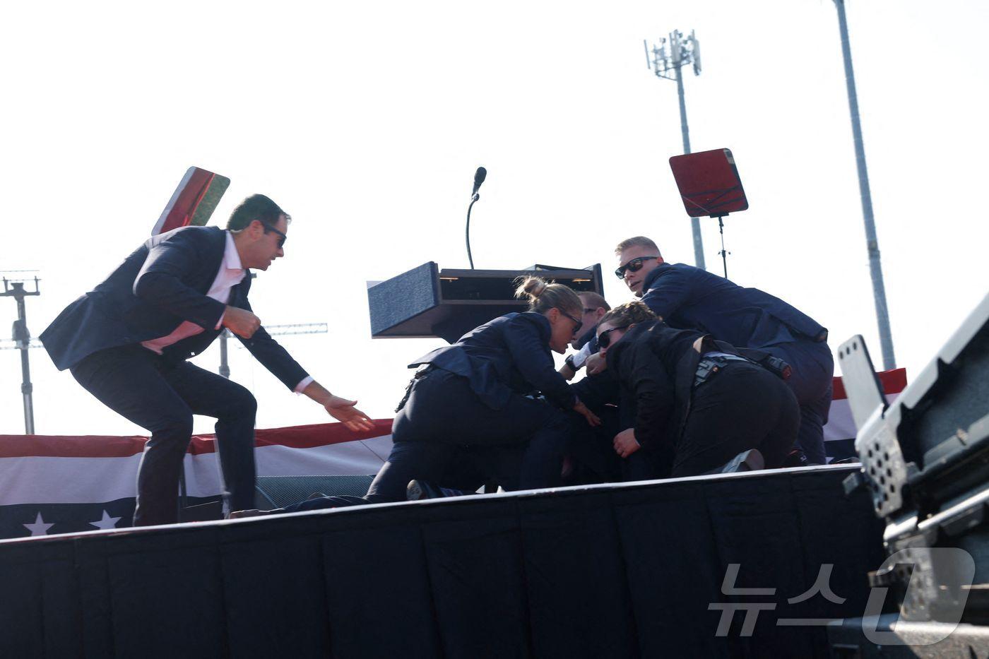 도널드 트럼프 미국 공화당 대선 후보가 13일(현지시간) 펜실베이니아주 버틀러에서 열린 선거 집회에서 총격 사건이 발생하자 경호원들이 트럼프를 둘러싸고 있다. ⓒ AFP=뉴스1 ⓒ News1 박형기 기자