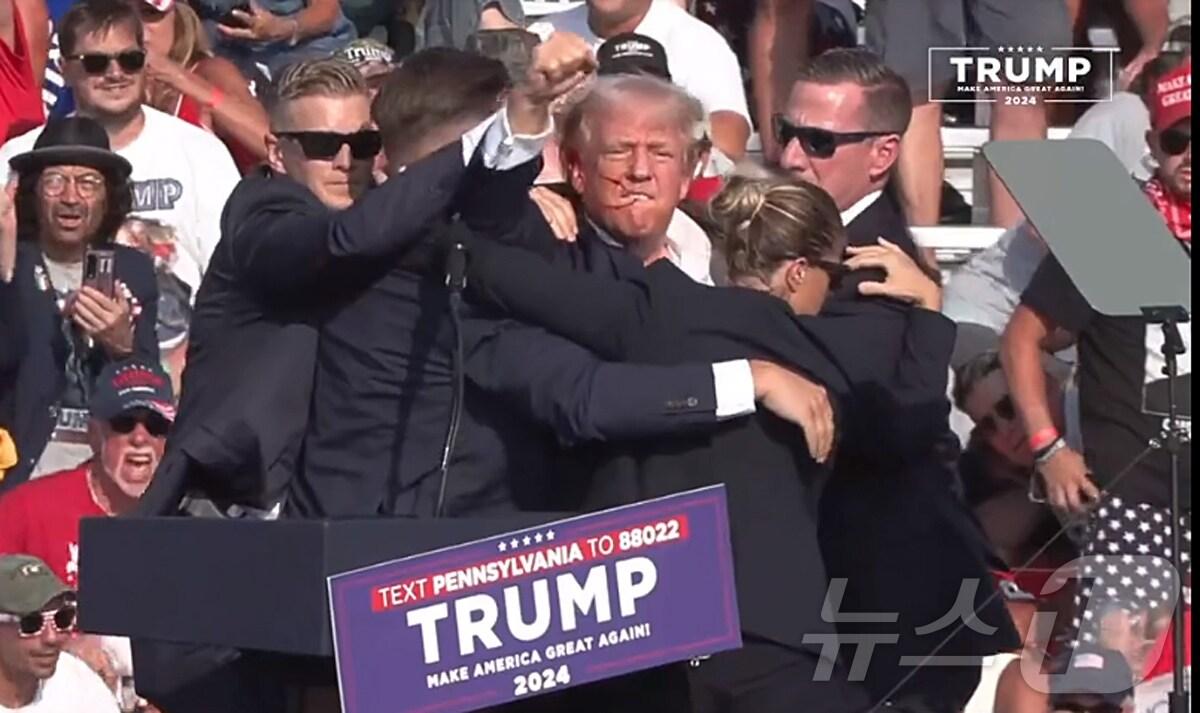 본문 이미지 - 미국 공화당 대선 후보인 도널드 트럼프 전 대통령이 13일 오후(현지시간) 펜실베이니아주 버틀러에서 유세를 벌이던 중 유세장 주변에서 여러 발의 총격이 발생하면서 유세가 중단됐다. 트럼프 전 대통령은 유세를 하던 중 총소리를 듣자 곧바로 몸을 연단 밑으로 숨겼고 경호원들의 보호를 받으며 무대에서 급히 대피했다. 트럼프 전 대통령은 몸을 피하면서 지지자들에게 주먹을 들어 보이며 건재함을과시 했다..(유튜브 캡처)2024.7.14/뉴스1