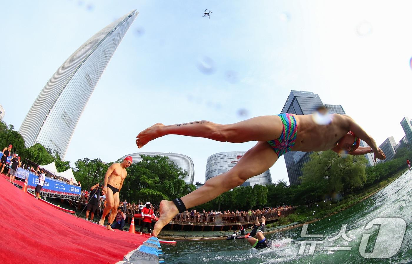 본문 이미지 - 14일 오전 서울 송파구 롯데월드타워 일대에서 열린 '2024 롯데 아쿠아슬론'에 출전한 참가자들이 석촌호수로 다이빙을 하고 있다.  (공동취재) 2024.7.14/뉴스1 ⓒ News1 임세영 기자
