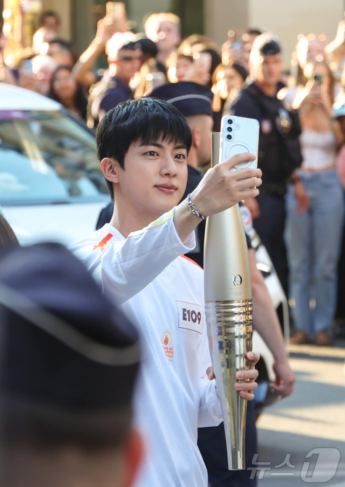 본문 이미지 - 2024 파리 올림픽 성화 봉송 주자로 나선 아이돌 그룹 방탄소년단(BTS)의 맏형 진이 프랑스 혁명기념일인 14일(현지시간) 프랑스 파리 루브르 박물관 인근 도로에서 성화를 전달받기 전 셀피 촬영을 하고 있다. 2024.7.15/뉴스1 ⓒ News1 이준성 기자