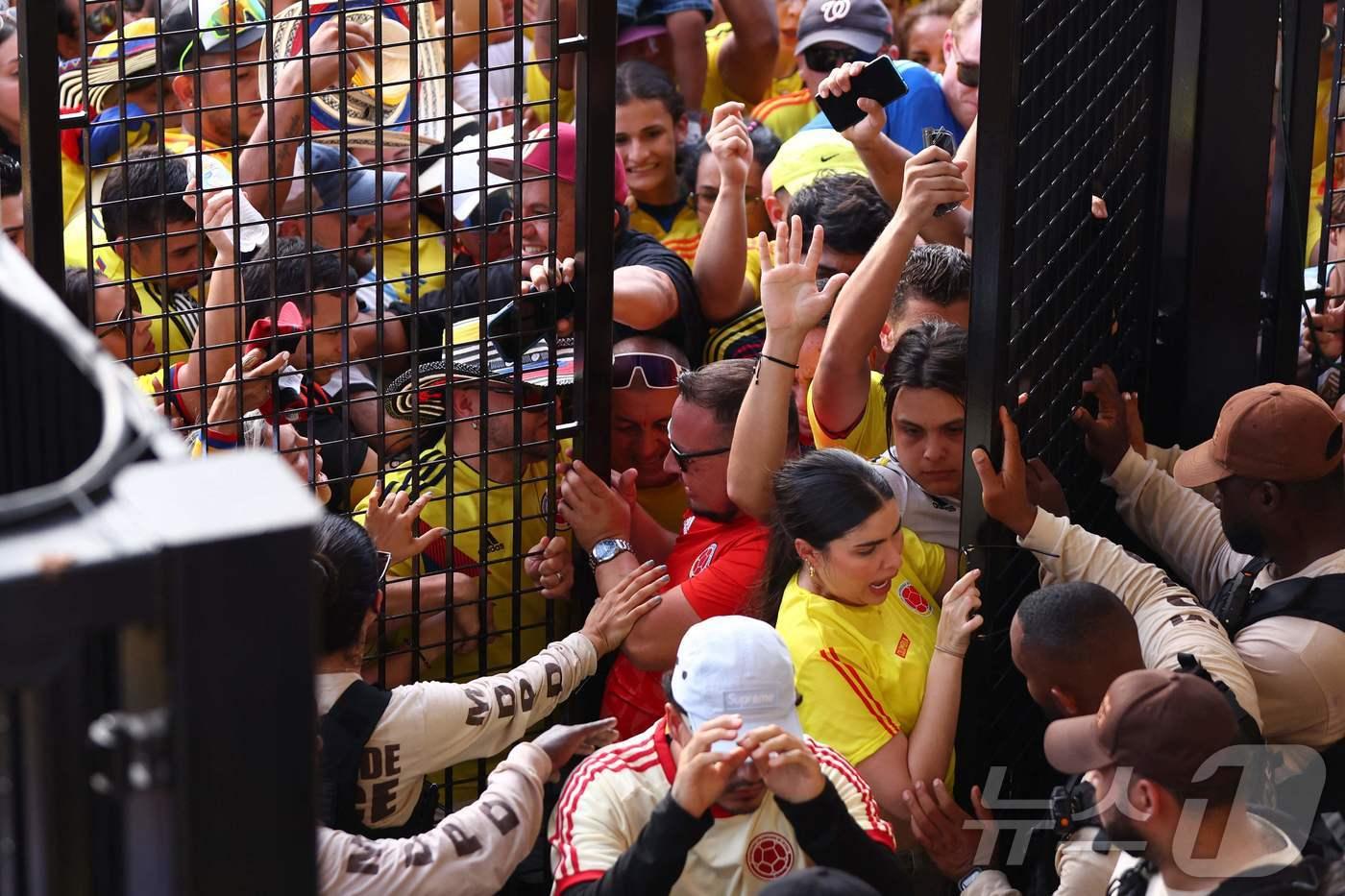 콜롬비아 팬들이 15일(한국시간) 입장권 없이 2024 코파 아메리카 결승전을 관전하려다 보안요원으로부터 제지당하고 있다. ⓒ AFP=뉴스1