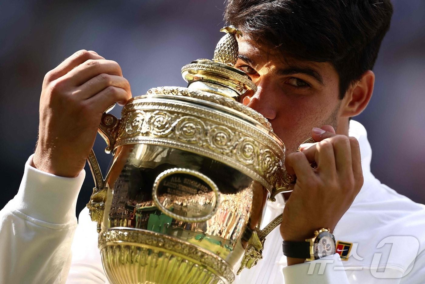 스페인의 카를로스 알카라스가 14일(현지시간) 영국 런던의 올잉글랜드 클럽에서 열린 윔블던 테니스 대회 남자 단식 결승에서 세르비아의 노바크 조코비치를 꺾고 2연패를 한 뒤 우승 트로피에 입을 맞추고 있다. 2024.07.15 ⓒ AFP=뉴스1 ⓒ News1 우동명 기자