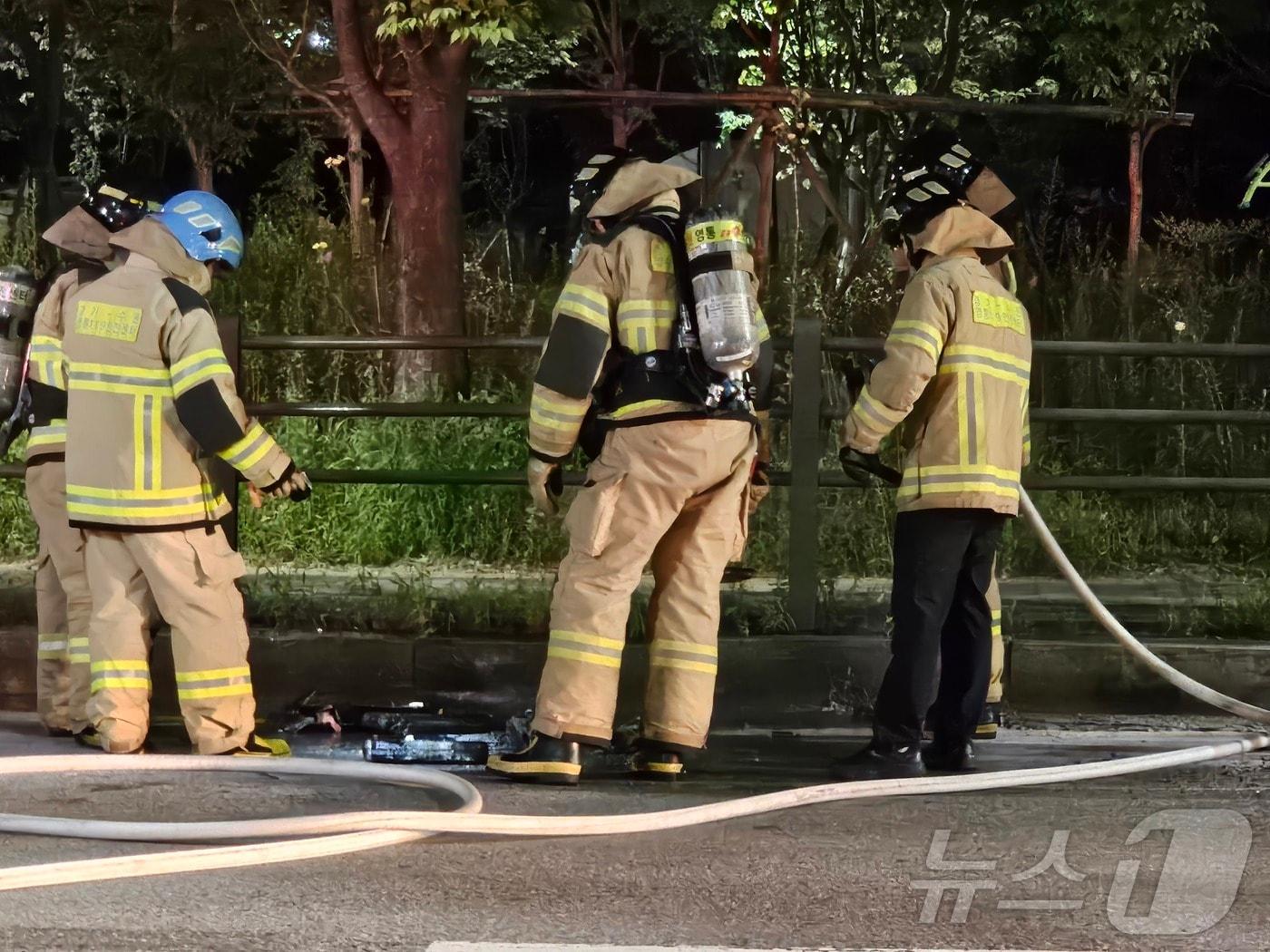 본문 이미지 - 16일 0시 54분쯤 경기 수원시 영통구 망포동 한 도로를 달리던 차량 내 전기 자전거용 배터리에서 불이 나 소방 당국이 안전 조치를 취하고 있다. 2024.7.16/뉴스1 ⓒ News1 김기현 기자