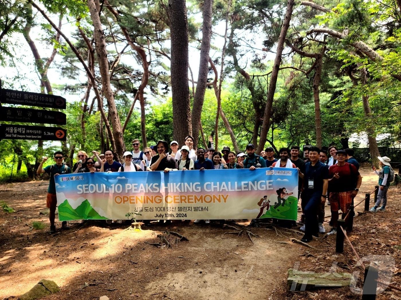본문 이미지 - 서울 도심 10대 명산 챌린지 참가자들이 북한산 둘레길에서 단체사진을 촬영하고 있다(서울관광재단 제공)